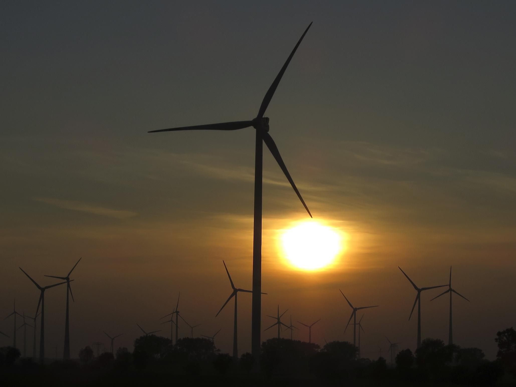 The sun sets behind power-generating wind turbines from a wind farm near the village of Ludwigsburg, northern Germany
