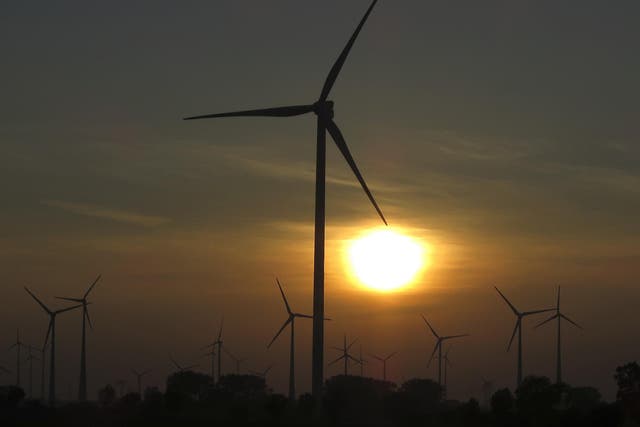 The sun sets behind power-generating wind turbines from a wind farm near the village of Ludwigsburg, northern Germany