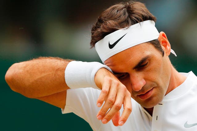 Roger Federer wipes sweat away from his brow at Wimbledon