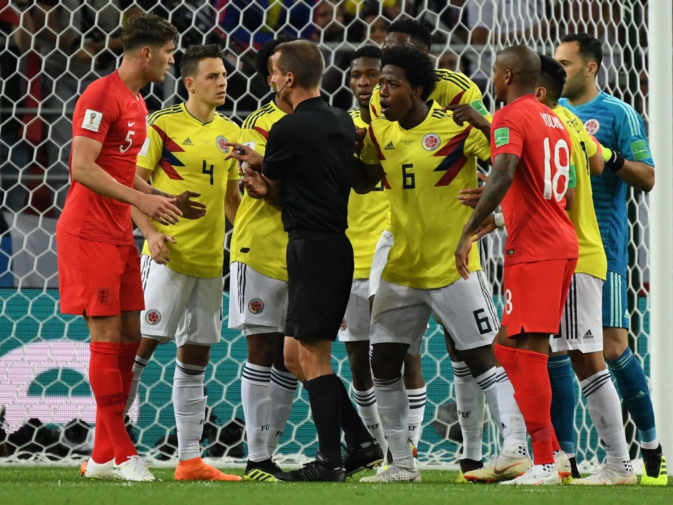 Colombia players confront referee Mark Geiger after he awarded England a penalty