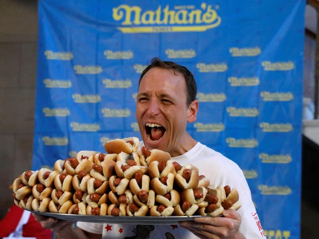 Current world record holder Joey Chestnut poses with a plate of hot dogs during the official weigh-in ceremony for the Nathan's Famous Fourth of July International Hot Dog Eating Contest in Brooklyn, New York City, on 3 July 2017