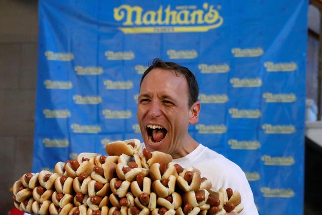 Current world record holder Joey Chestnut poses with a plate of hot dogs during the official weigh-in ceremony for the Nathan's Famous Fourth of July International Hot Dog Eating Contest in Brooklyn, New York City, on 3 July 2017