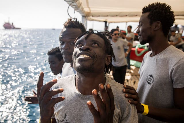 Migrants aboard the Open Arms aid boat as it approaches the port of Barcelona