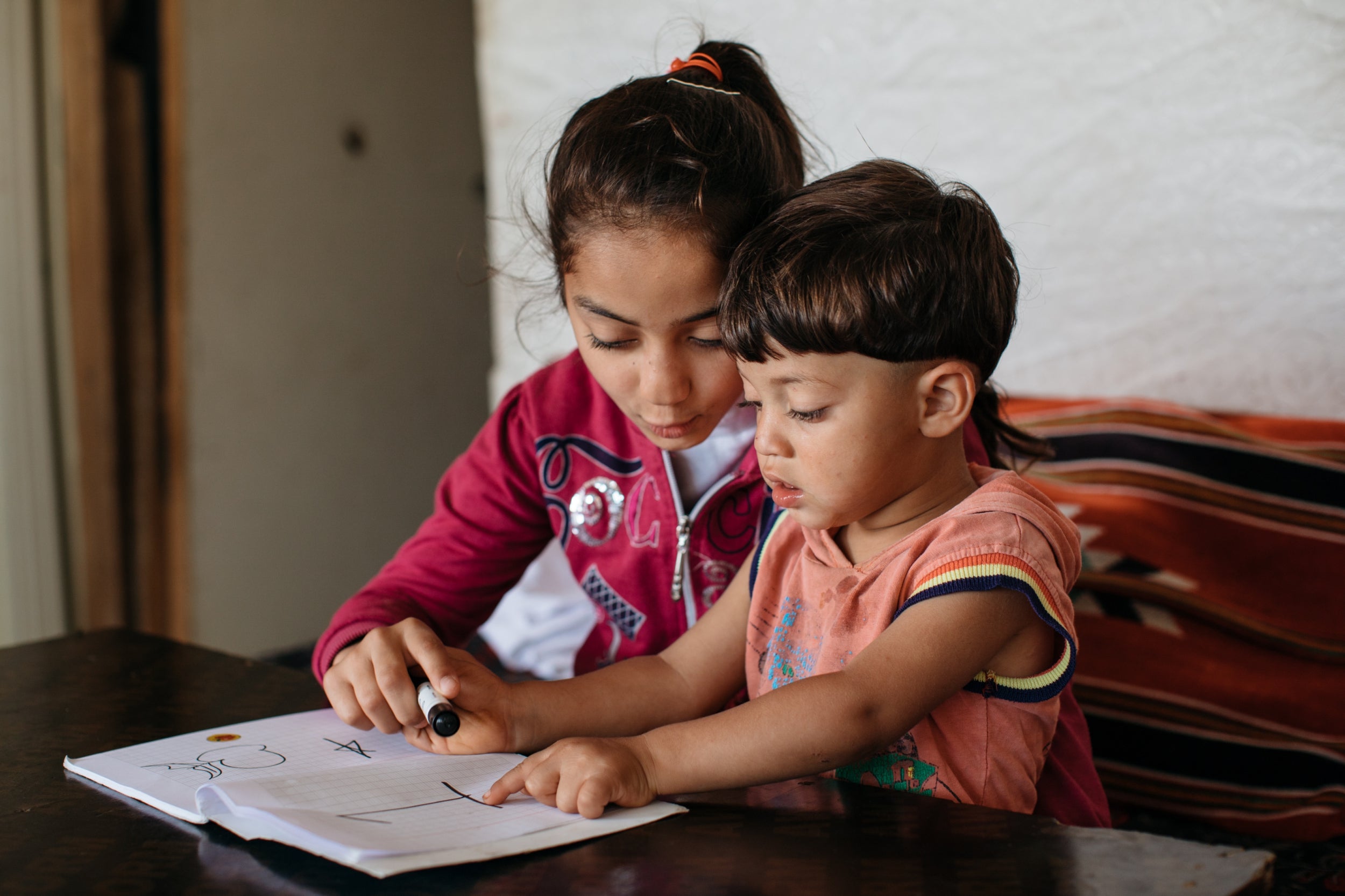 Hadi is taught some basics of English by his sister Sara to prepare him for enrolment into an UNRWA school when he is six