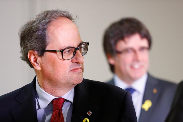 Regional leader of Catalonia Quim Torra (left) and his predecessor Carles Puigdemont (right) attend