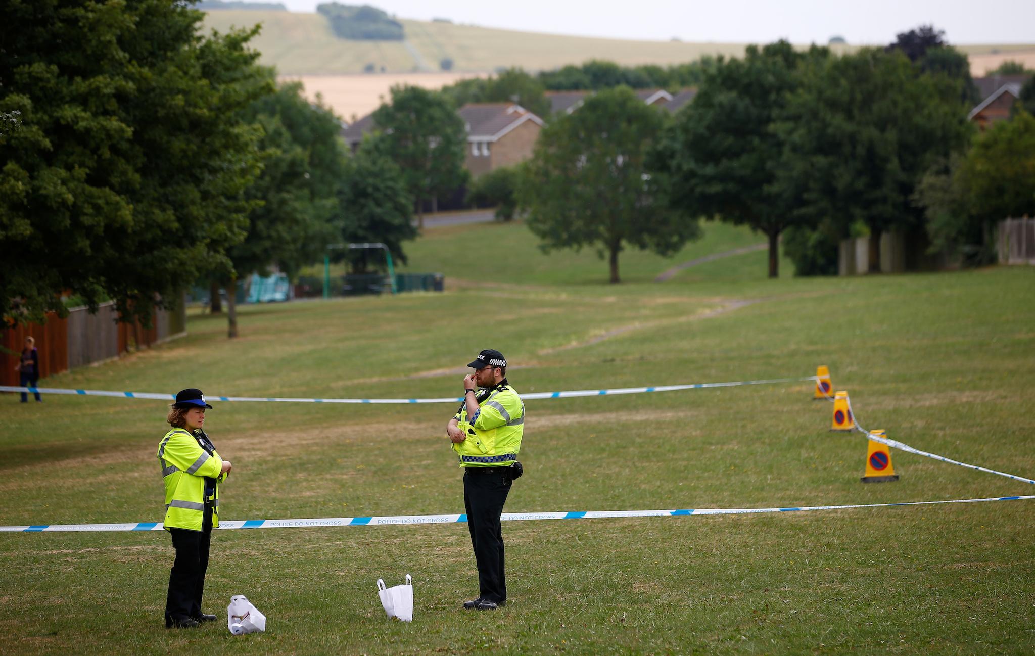Police officers stand next to a section of playing field near Amesbury Baptist Church, which has been cordoned off after two people were hospitalised and police declared a 'major incident', in Amesbury