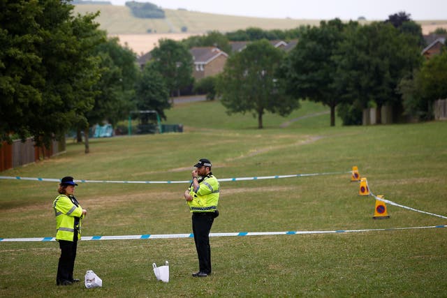 Police officers stand next to a section of playing field near Amesbury Baptist Church, which has been cordoned off after two people were hospitalised and police declared a 'major incident', in Amesbury
