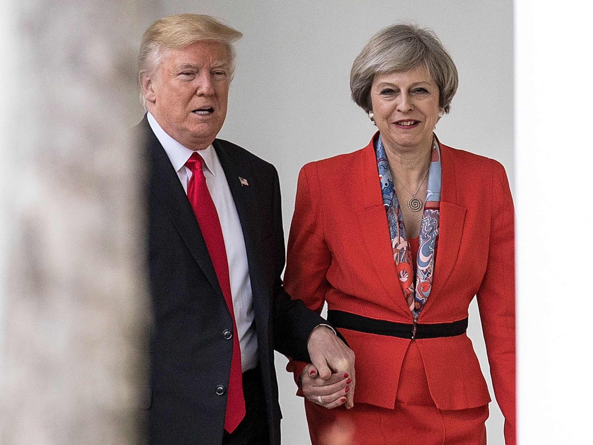 Theresa May holding hands with Donald Trump
