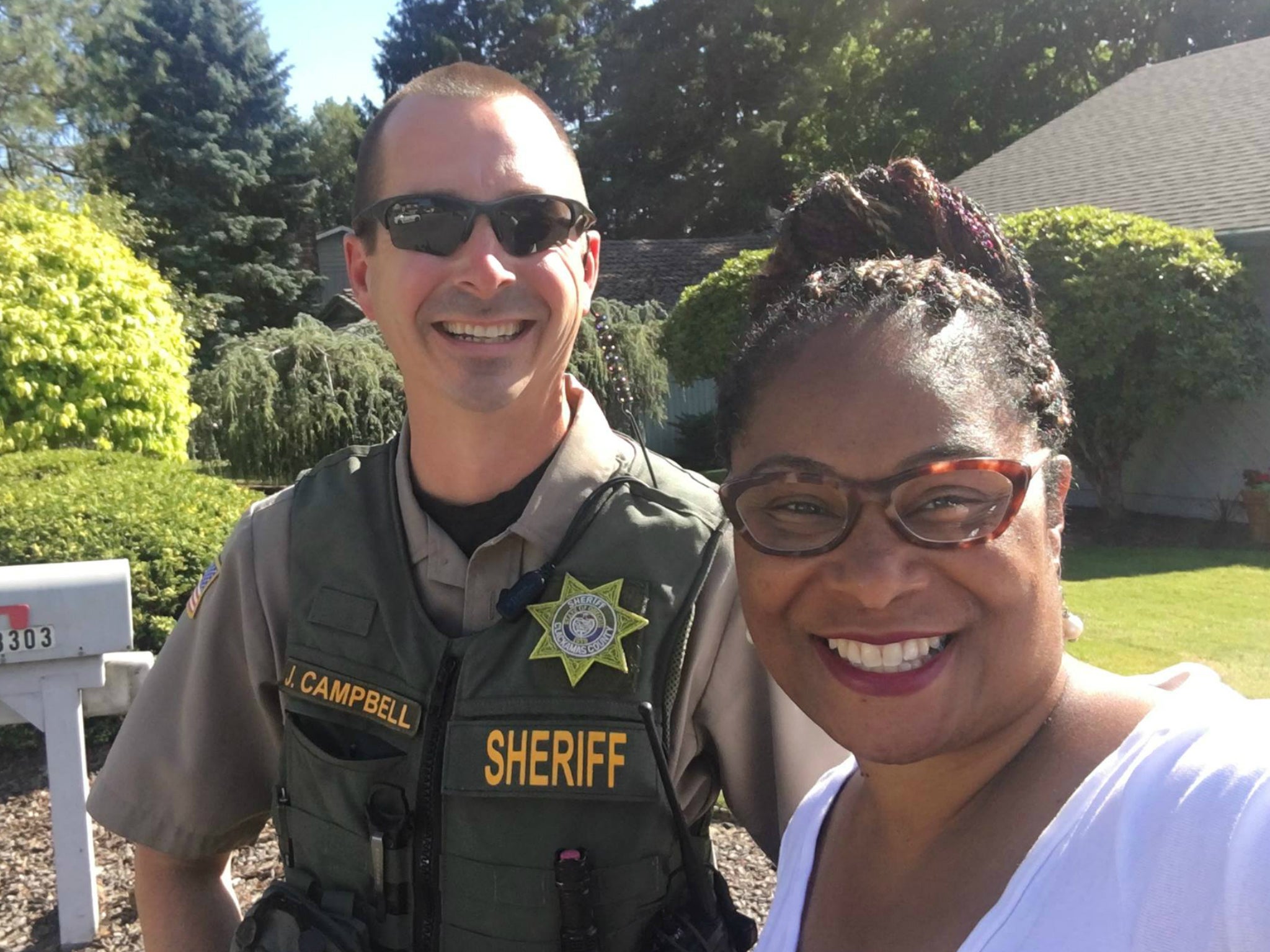 Oregon State Representative Janelle Bynum takes a picture with Officer Campbell of the Clackamas County Sheriff's office after a voter called police to report the candidate for campaigning door-to-door
