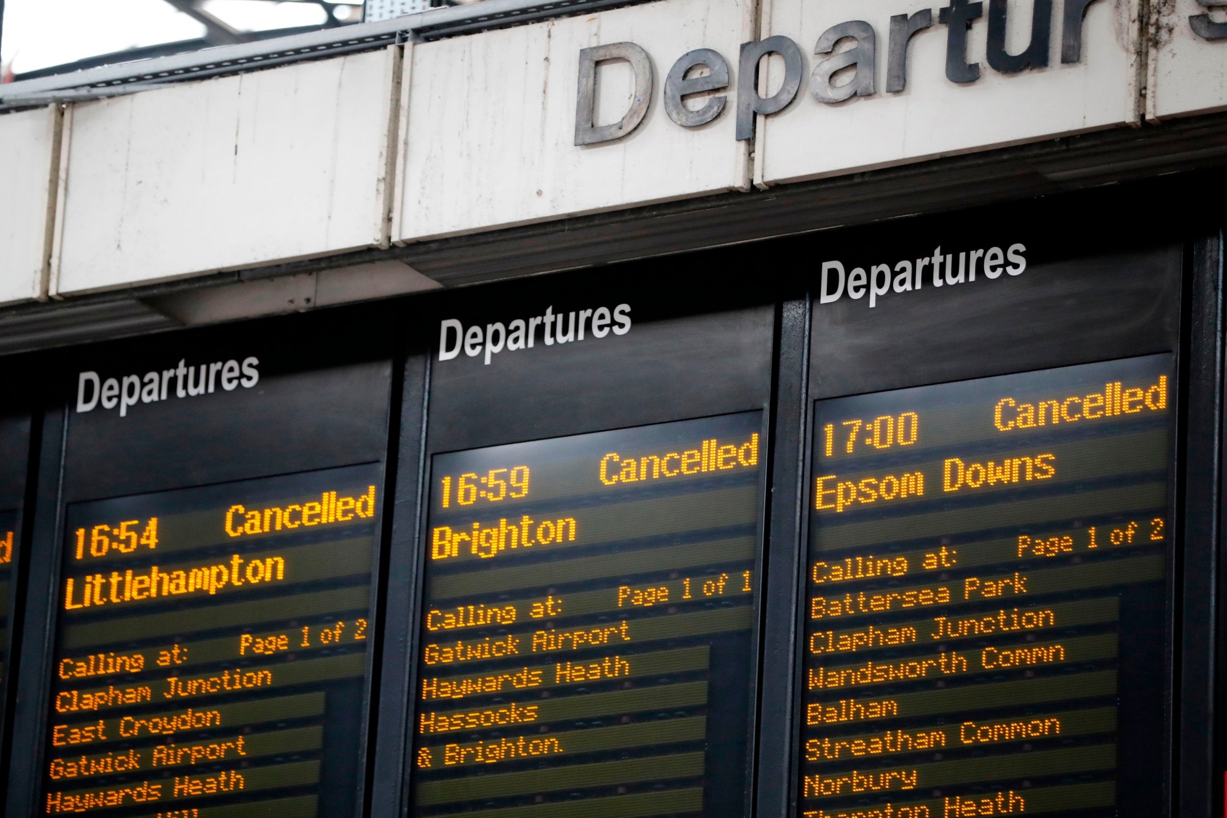 Departure boards at London’s Victoria railway station display a list of cancelled trains