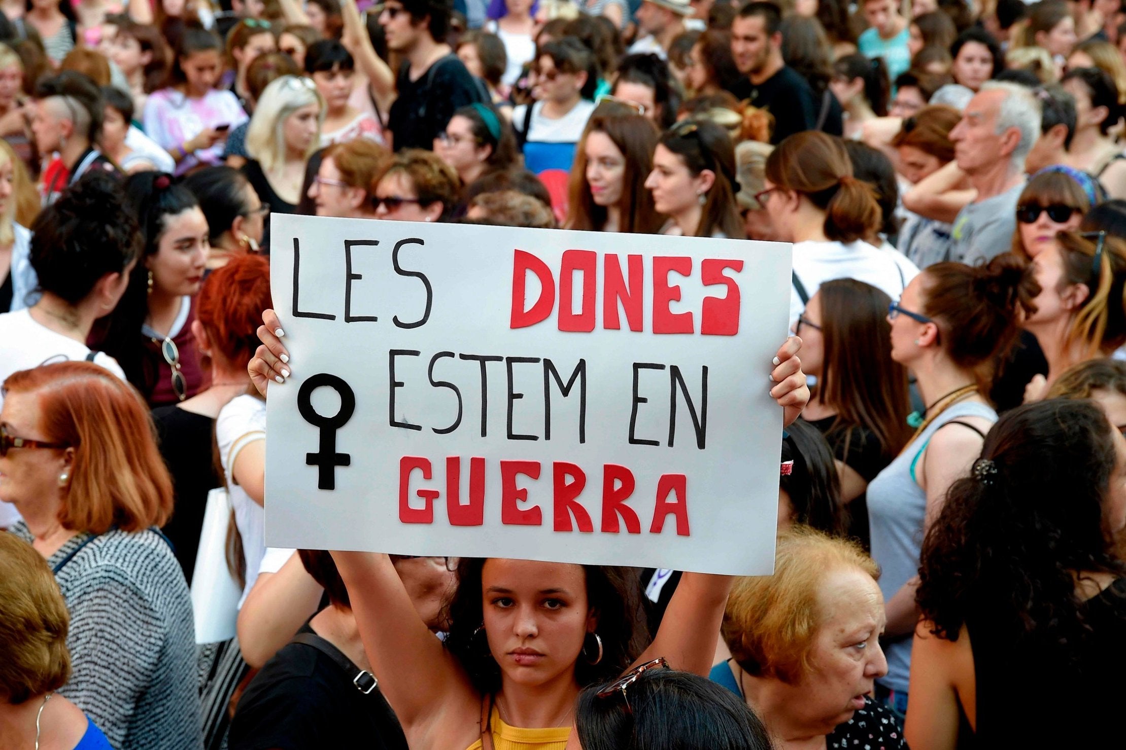 A woman holds a placard reading "The women are at war" during a demonstration in Valencia on June 22, 2018, after the court ordered the release on bail of the five men involved in the "Wolf Pack" case.