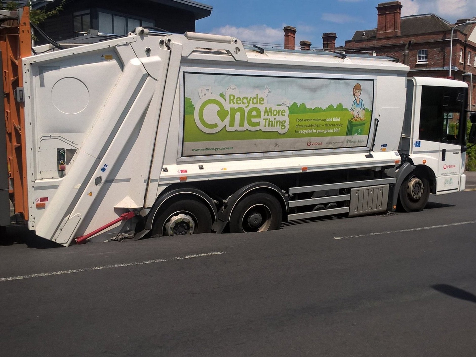 A bin lorry stuck after the carriageway gave way after the summer heat melted the asphalt in Old Bath Road