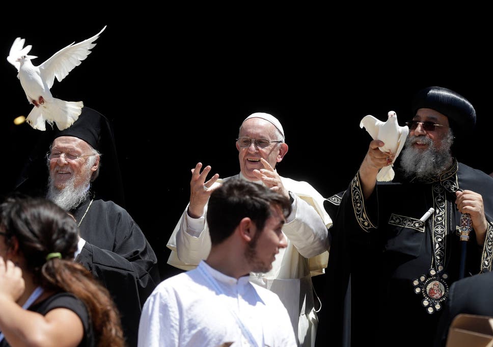 Pope Francis, center, flanked by Ecumenical Patriarch Bartholomew I, left, and Tawadros II, Pope of Alexandria and Patriarch of the See of St. Mark, free doves in Bari