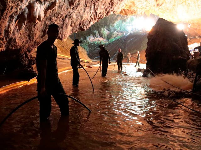 Thai rescue teams pump water out of the flood cave near the entrance to the complex.
