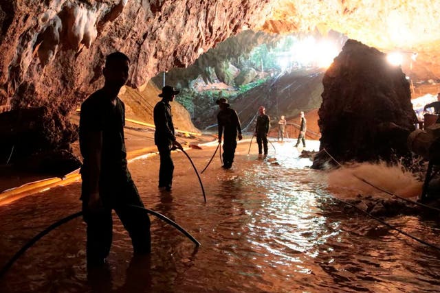 Thai rescue teams pump water out of the flood cave near the entrance to the complex.