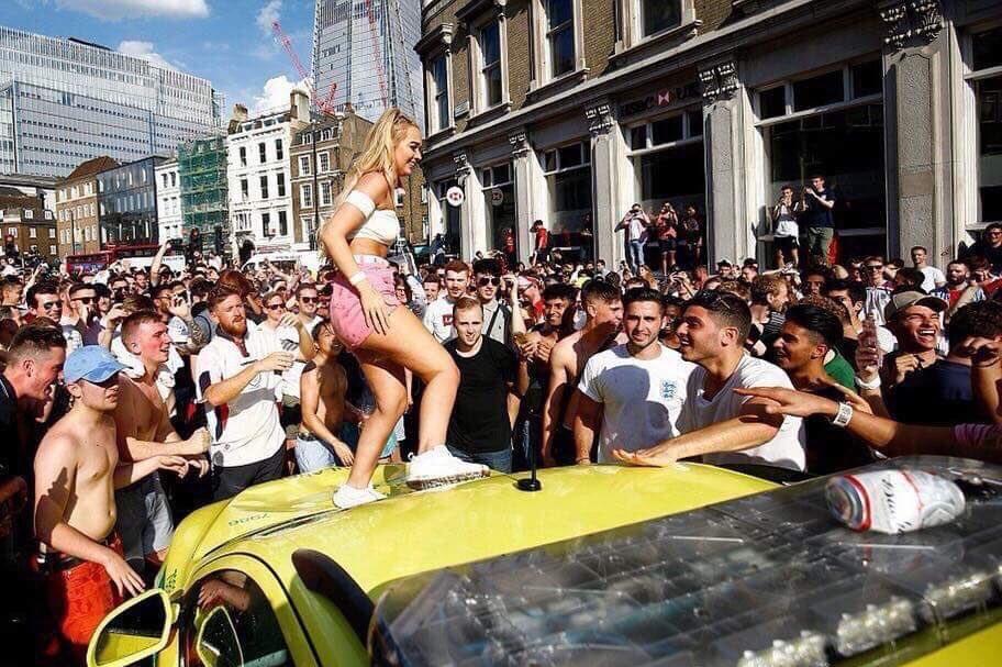 An England fan dances on a London Ambulance Service response vehicle (Reuters)