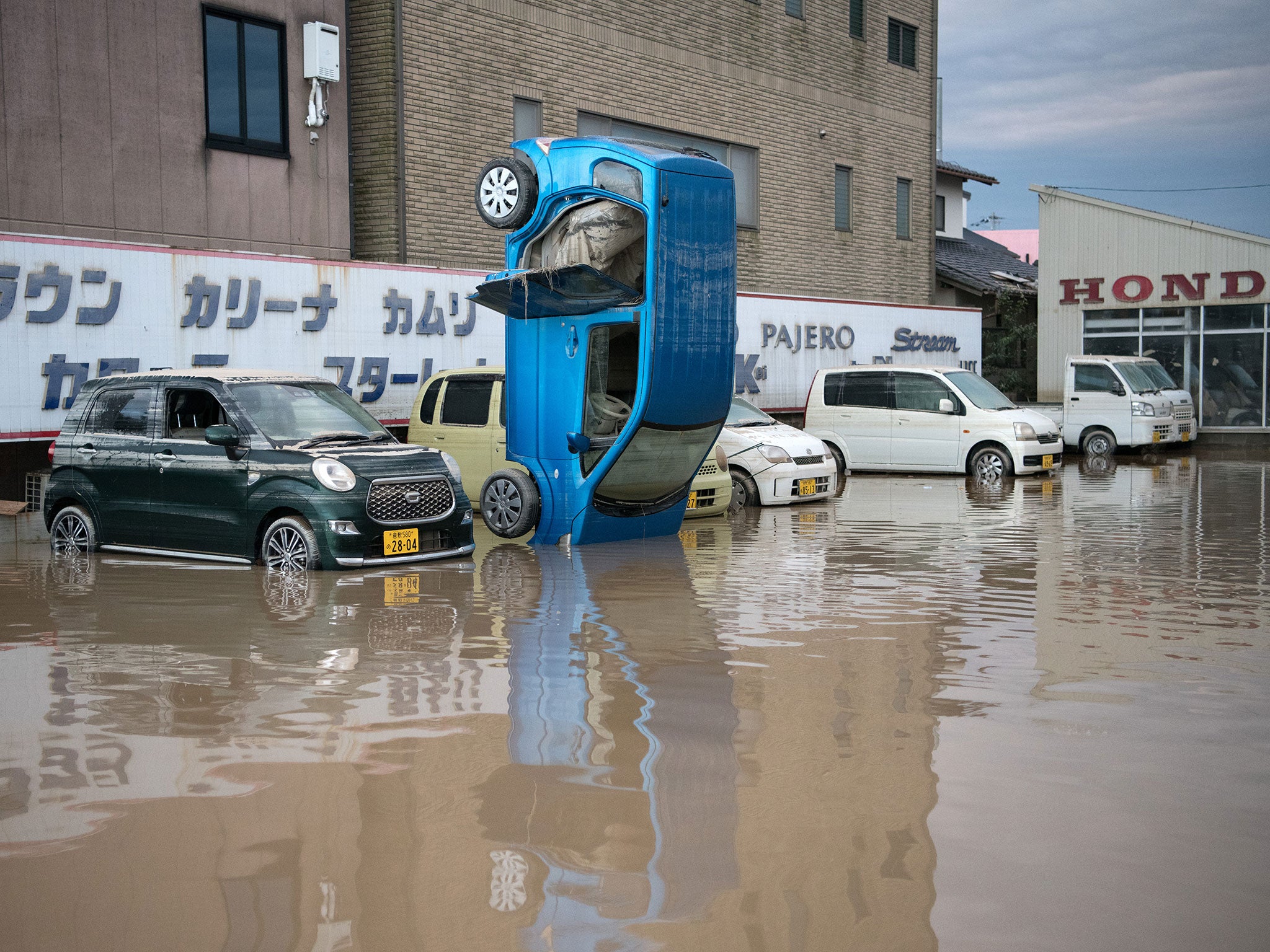 A car stands on its front after heavy flooding (Getty)