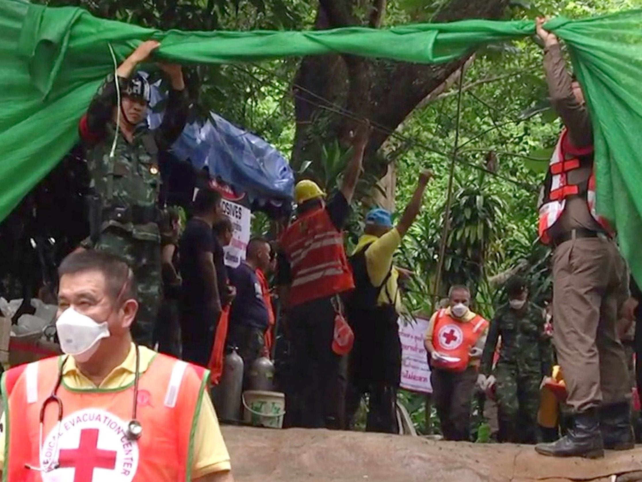 Emergency workers carry a boy from the flooded Tham Luang caves
