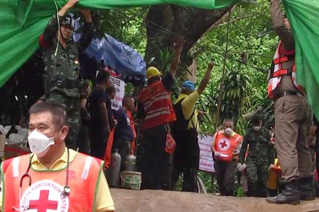 Emergency workers carry a boy from the flooded Tham Luang caves