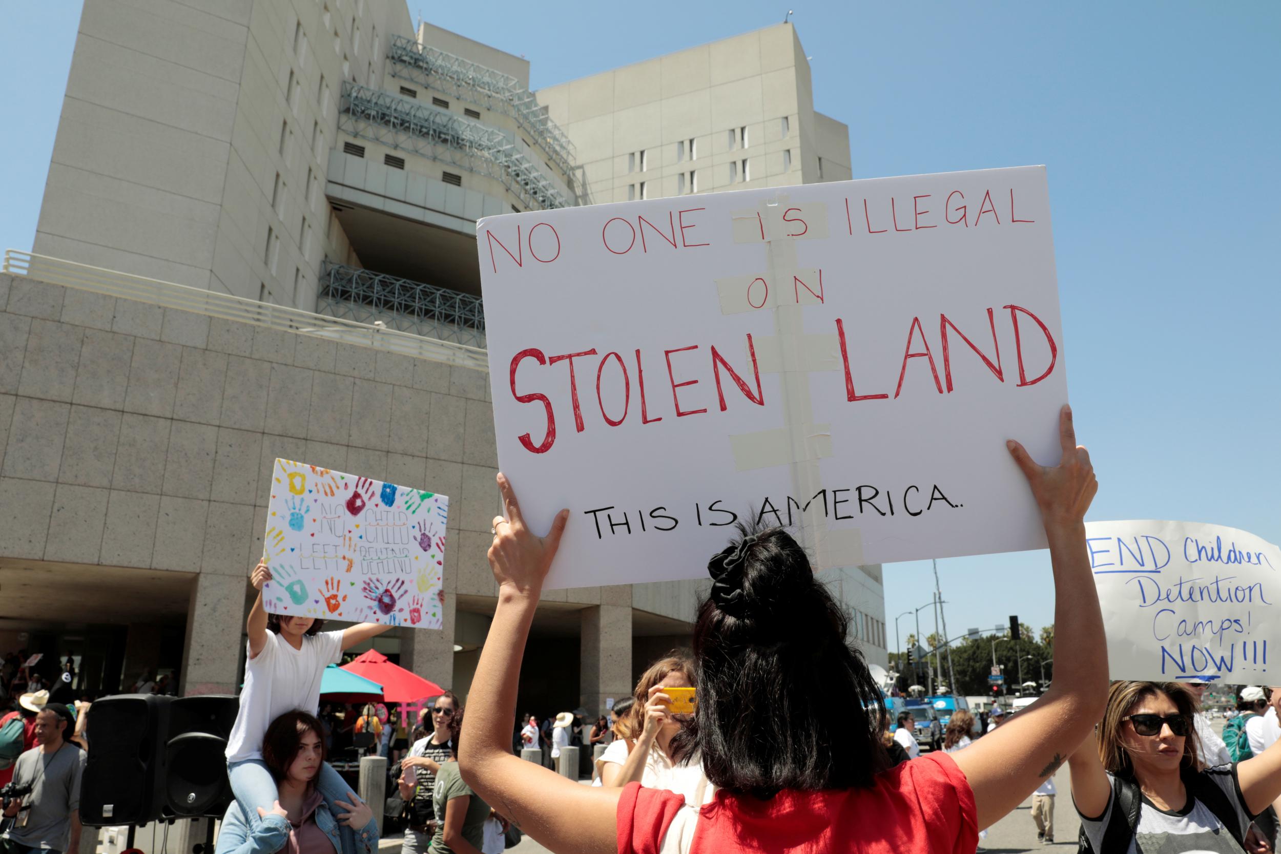 Demonstrators protest in front of the Metropolitan Detention Centre, Federal Bureau of Prisons, during a national day of action called “Keep Families Together” against the Trump administration’s ‘Zero Tolerance’ policy in Los Angeles on 30 June