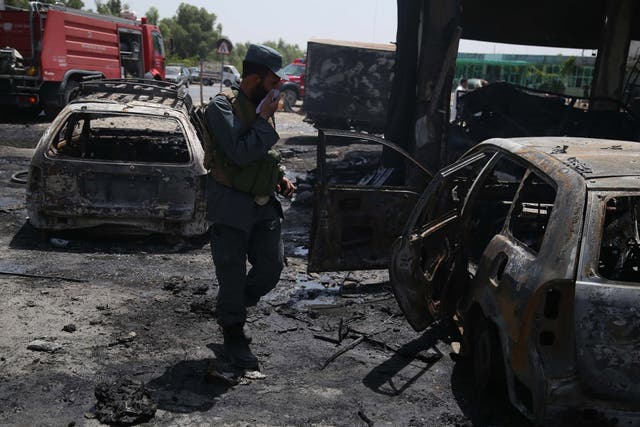 Afghan security officials inspect the scene of the attack that targeted the National Directorate of Security soldiers in Jalalabad