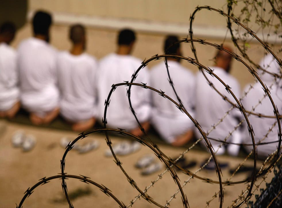 A group of detainees kneel during an early morning prayer