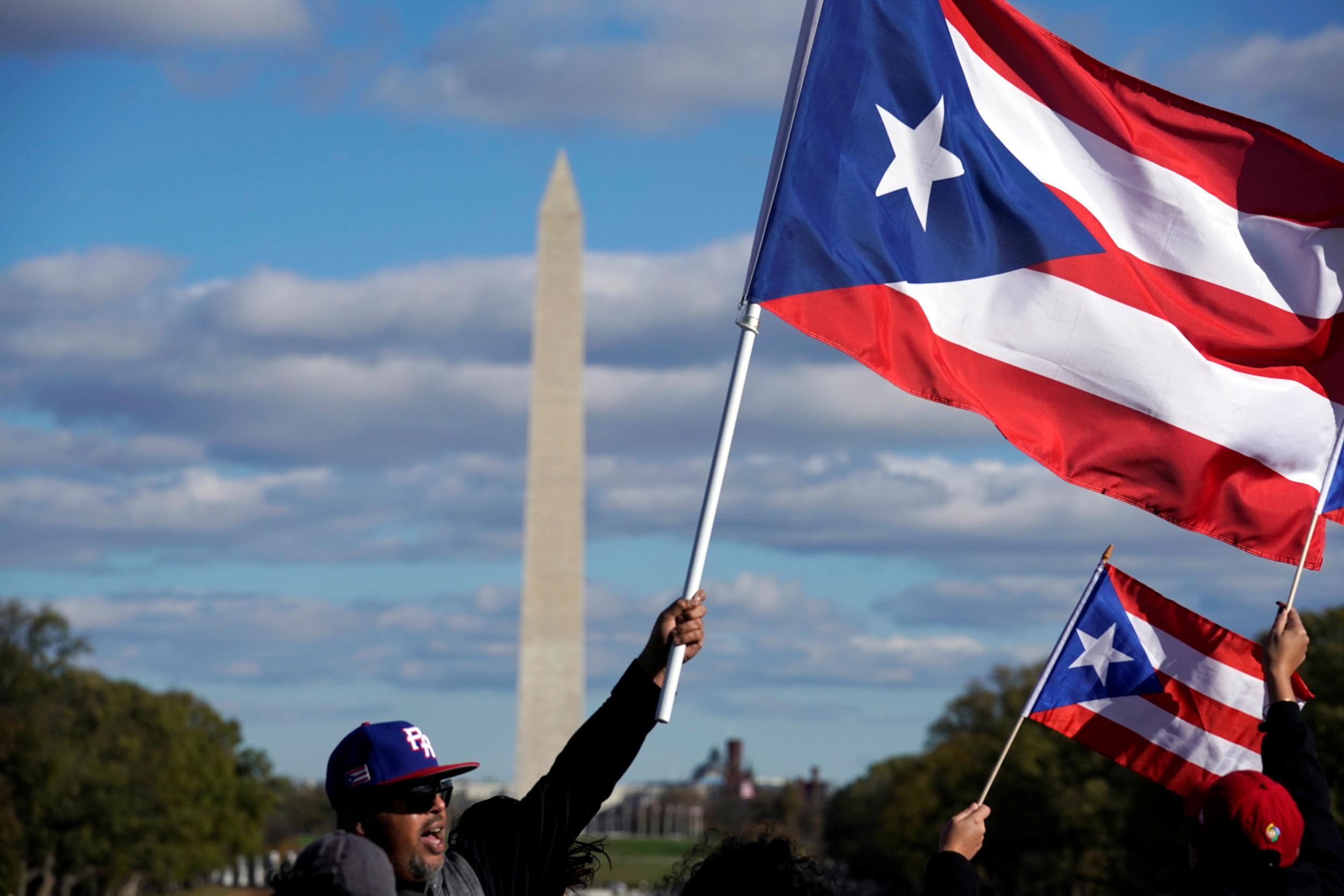 People wave Puerto Rican flags at the Unity March to highlight the ongoing humanitarian and natural disaster crisis in Puerto Rico, at the Lincoln Memorial in Washington, U.S., November 19, 2017.