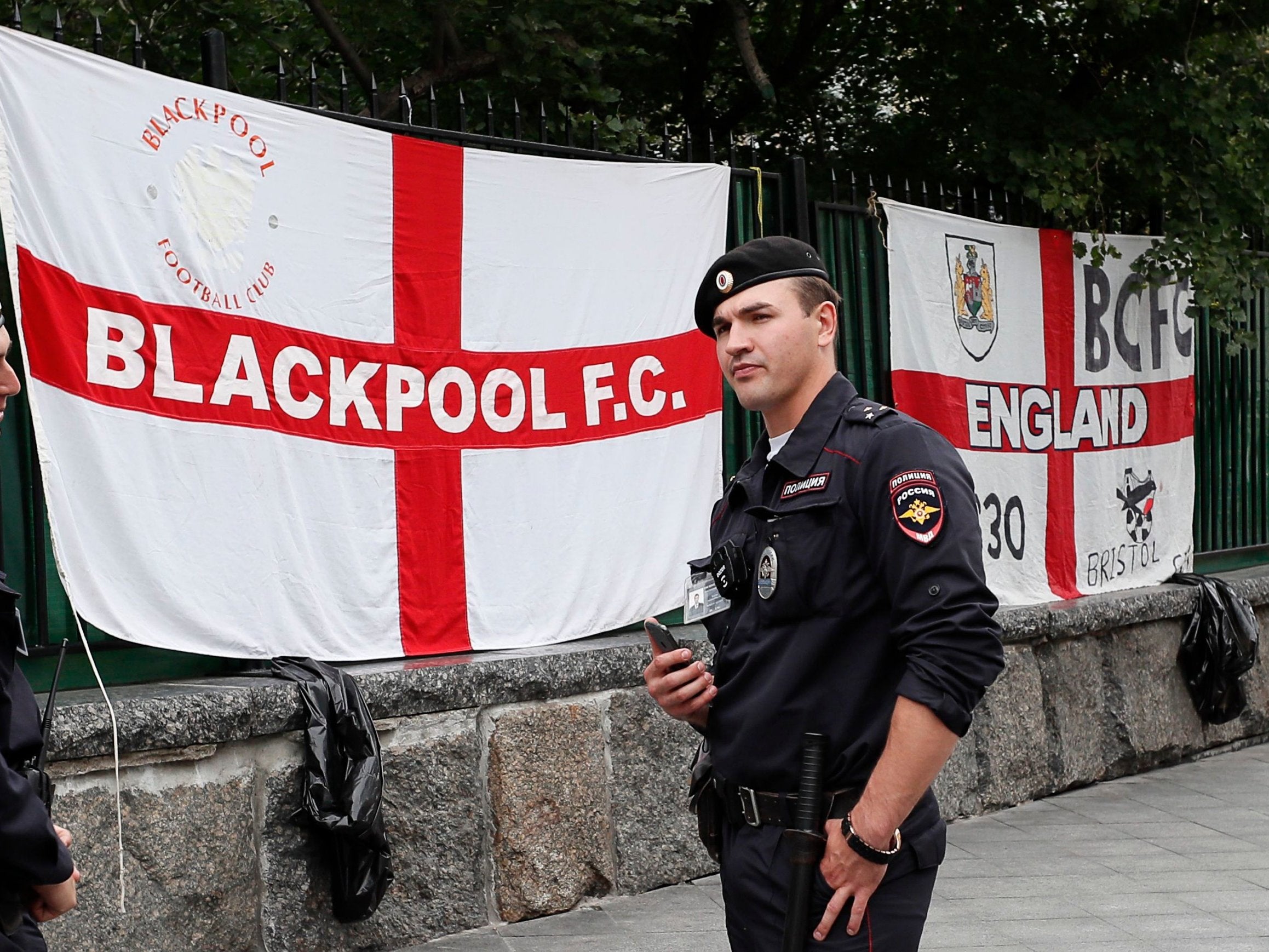 Russian policemen stand guard near England flags