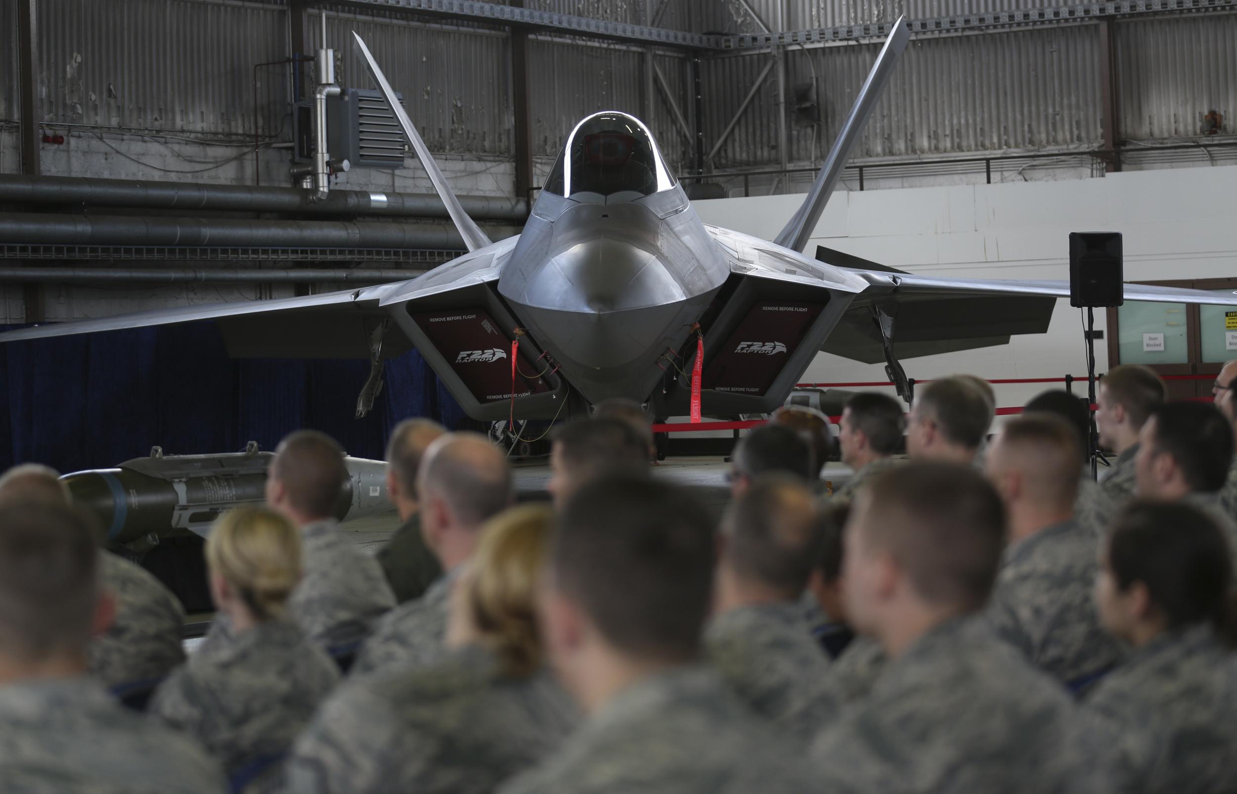 Soldiers listen in front of an U.S. Air Force F-22 Raptor fighter jet during a briefing in a hangar at the U.S. Spangdahlem Air base, Germany