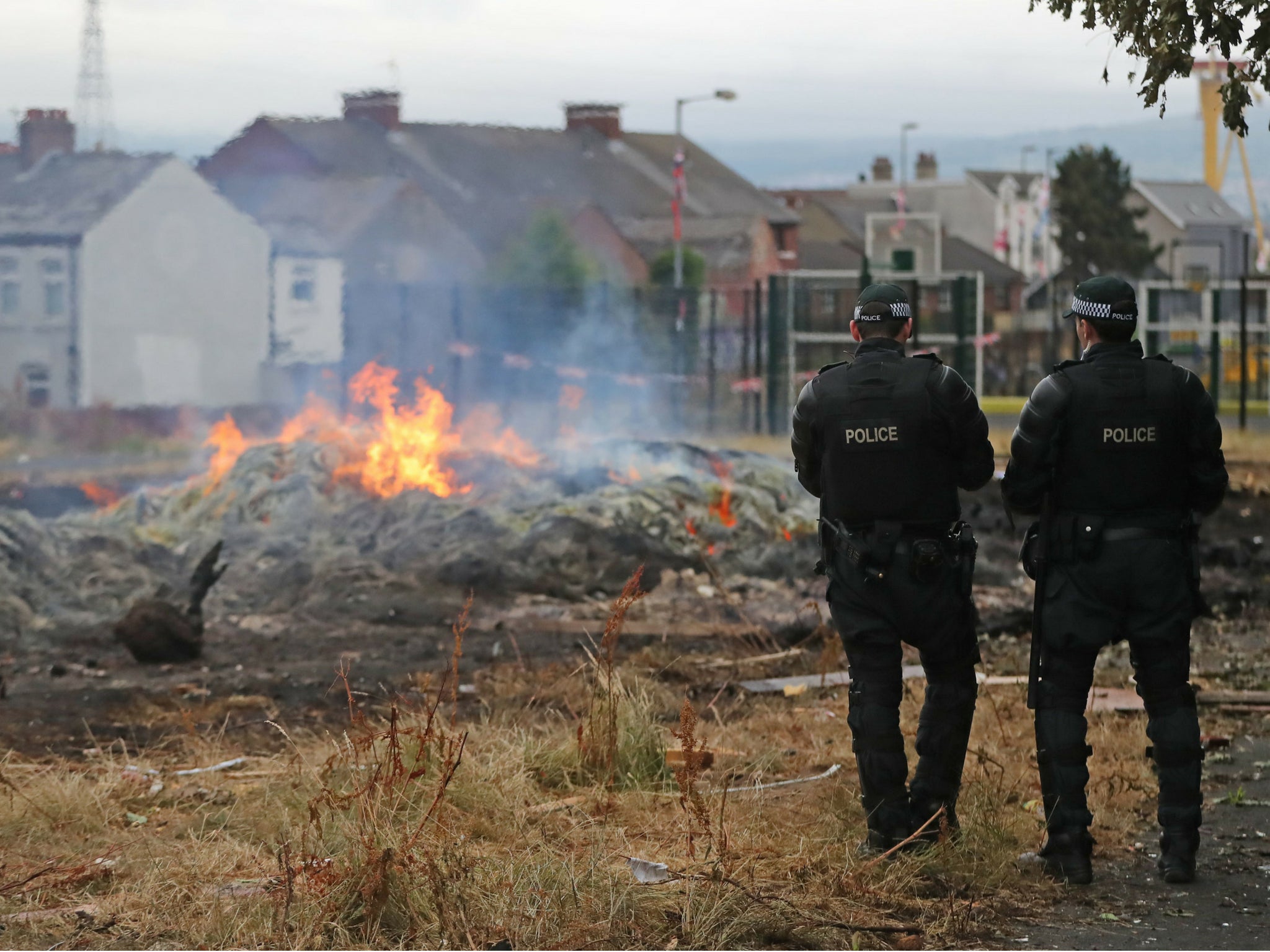 Contractors flanked by police dismantled two pyres in east Belfast on Wednesday