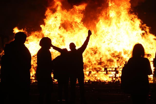 People attend an 11th night Bonfire in the Sandy Row area of Belfast