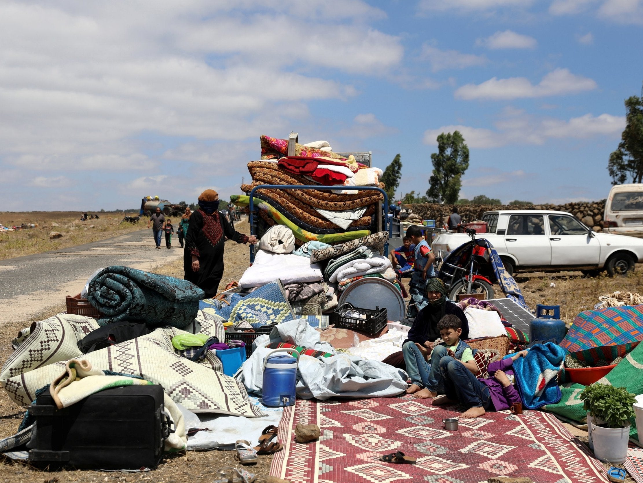 People from Deraa with their belongings near the Israeli-occupied Golan Heights in Quneitra