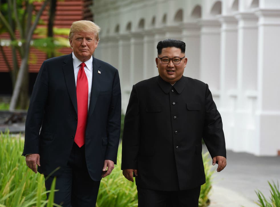 US President Donald Trump walks with North Korean Leader Kim Jong-un in Singapore during their historic summit 12 June 2018.