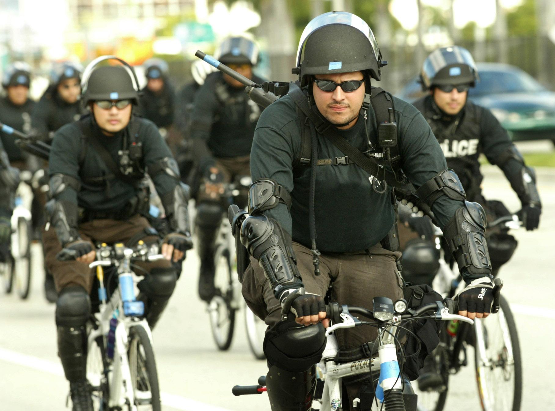Riot police ride bicycles on Biscayne Boulevard in Florida.