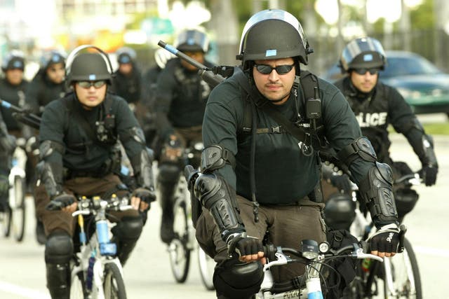 Riot police ride bicycles on Biscayne Boulevard in Florida.