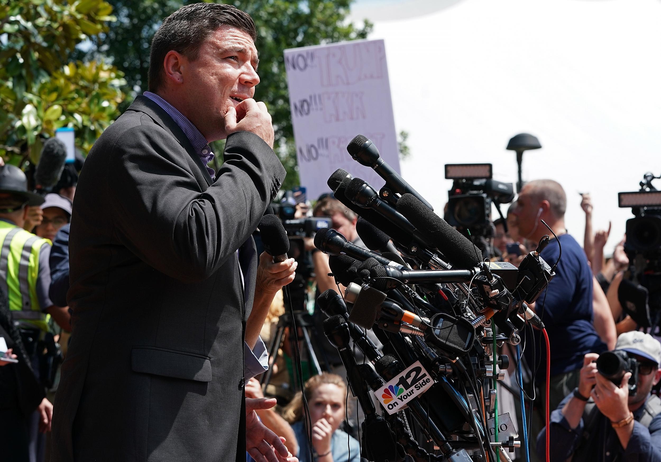 Jason Kessler, an organizer of 'Unite the Right' rally, tries to speak while being shouted down by counter protesters outside the Charlottesville City Hall