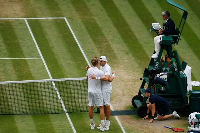 Kevin Anderson, left, and John Isner embrace after the match