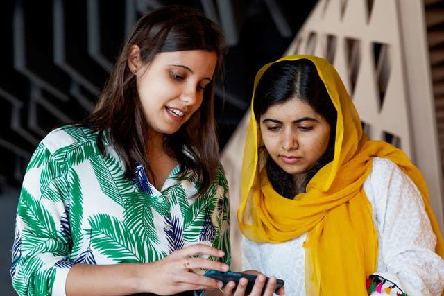 Brazilian student Beatriz Magalhães shows her project work to Malala Yousafzai in Rio de Janeiro on Friday