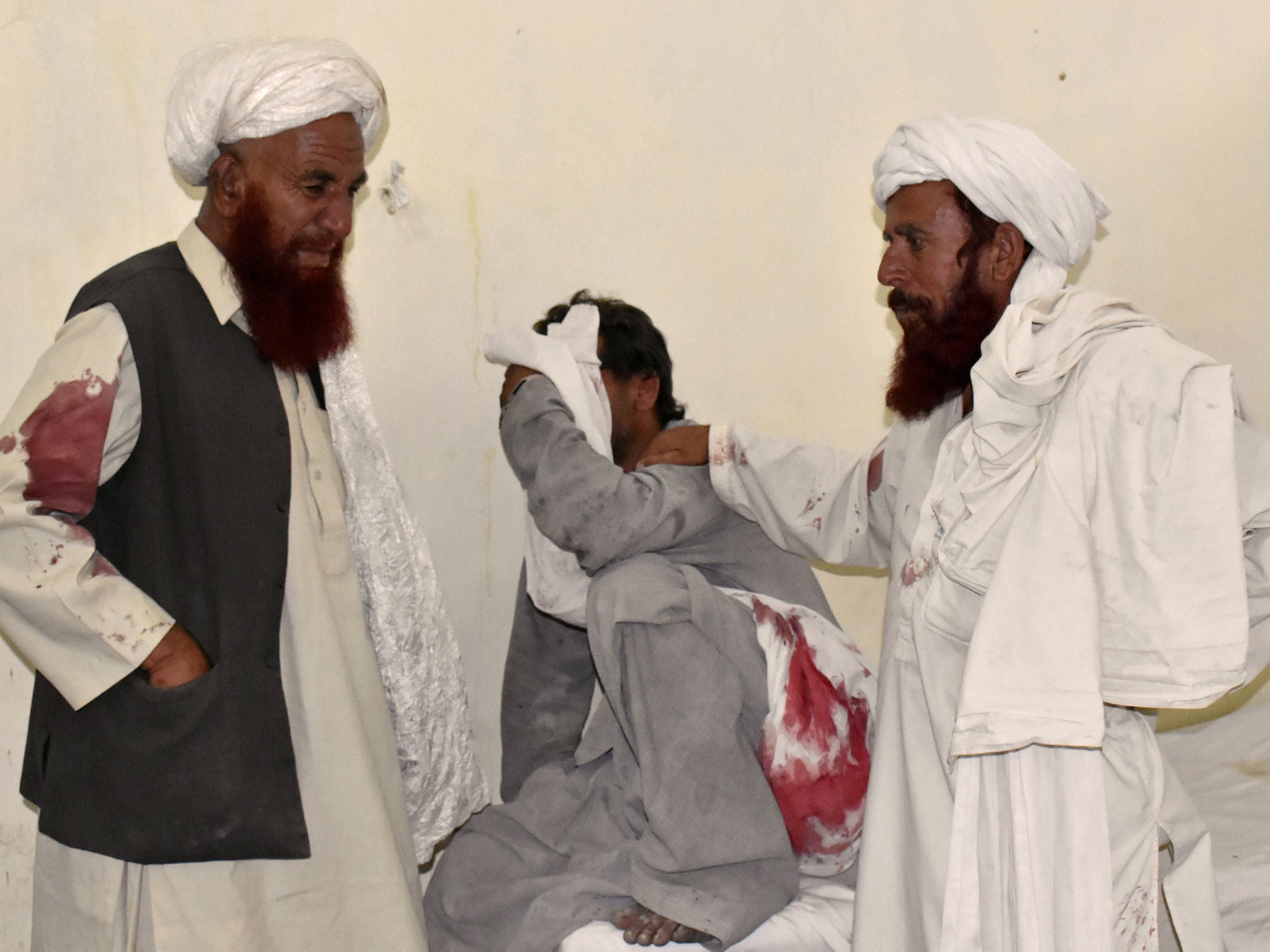 Men mourn the death of relatives and party workers at a hospital in Quetta