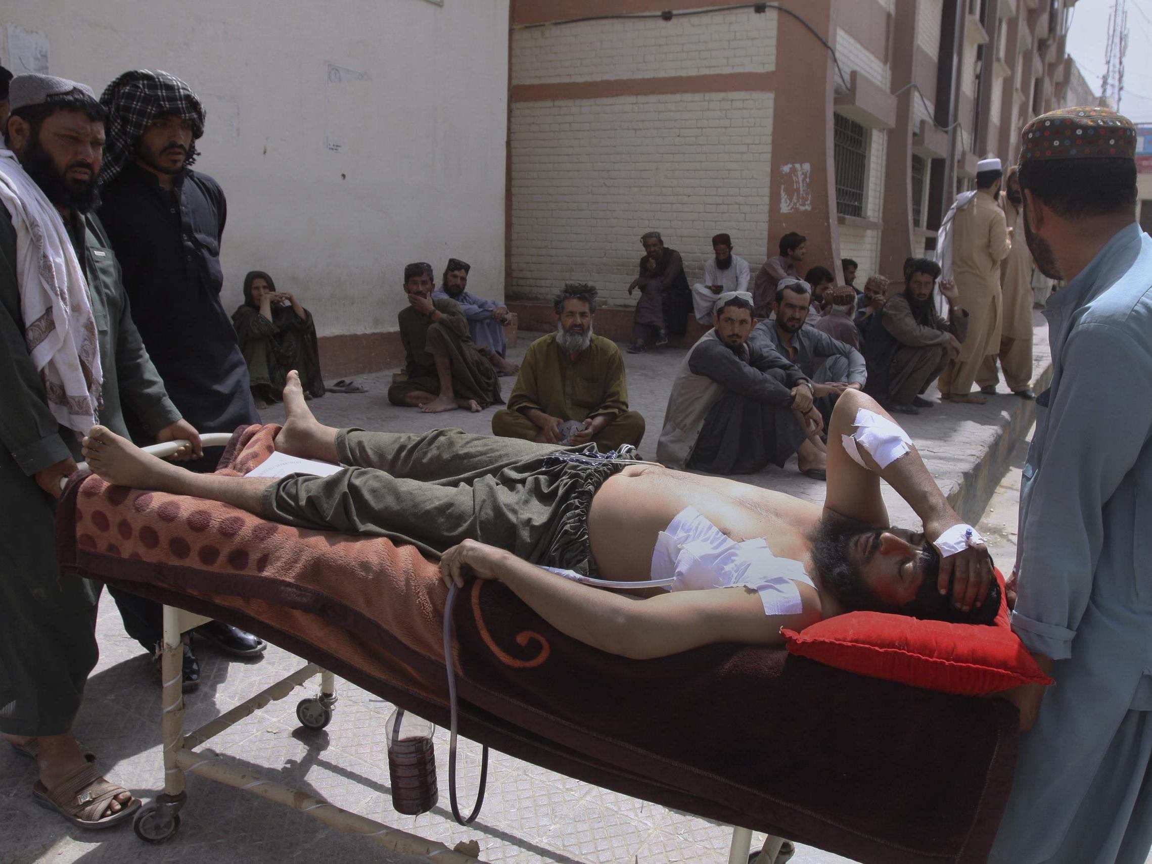 An injured man is carried to a hospital in Quetta, Pakistan, on Saturday, July 14, 2018, after a suicide bombing in Mastung on Friday.