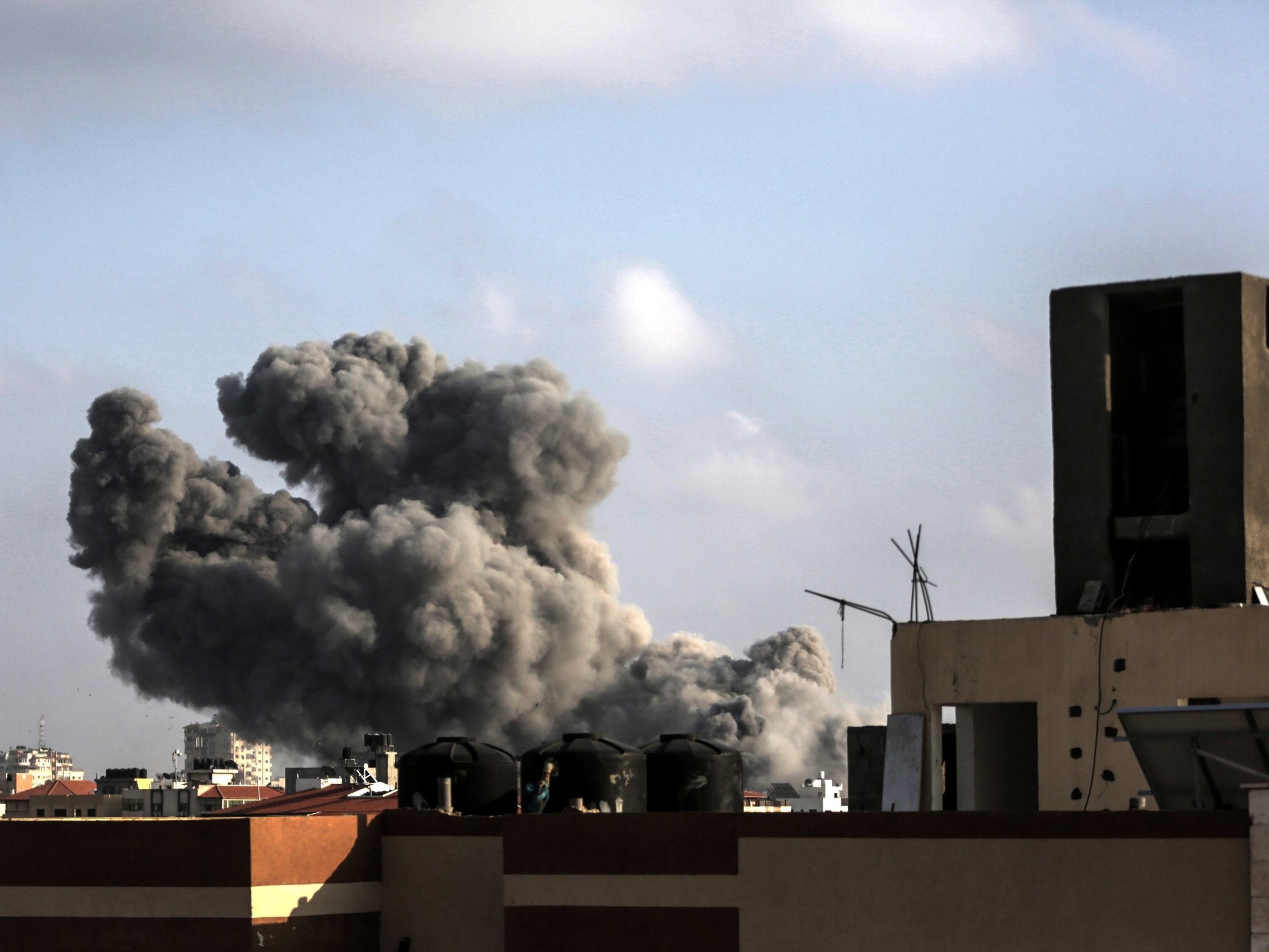 Smoke rises from a building after an Israeli air strike in central Gaza City on 14 July