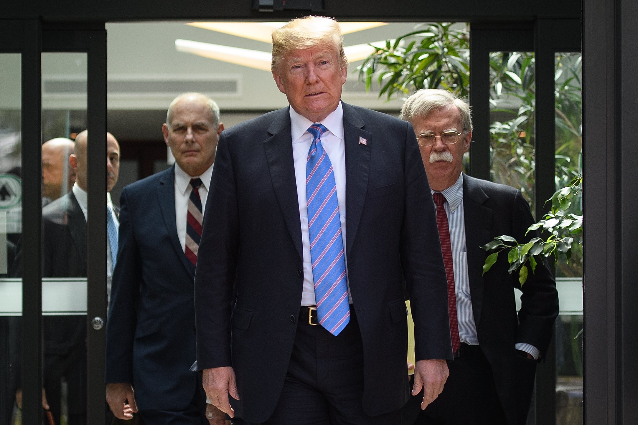US President Donald Trump leaves with Chief of Staff John Kelly and National Security Advisor John Bolton after a press conference at the G7 Summit