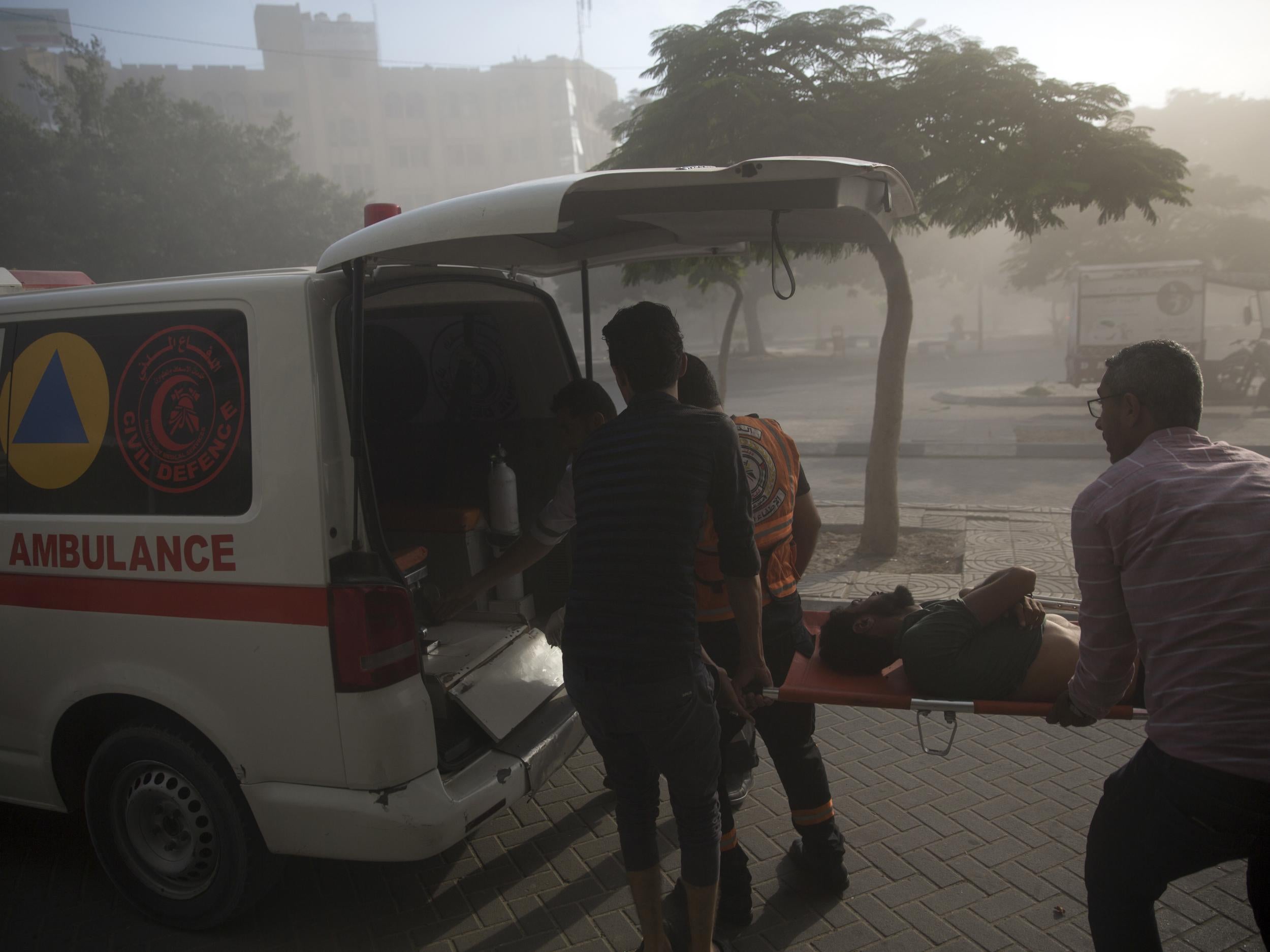 Medics evacuate a wounded Palestinian man following an Israeli airstrike hits a governmental building in Gaza City , Saturday, July 14, 2018