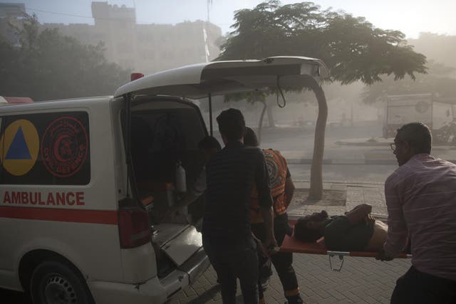 Medics evacuate a wounded Palestinian man following an Israeli airstrike hits a governmental building in Gaza City , Saturday, July 14, 2018