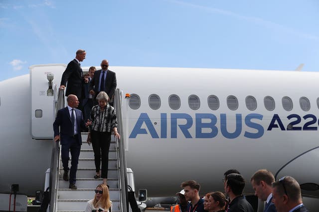 Theresa May talks with Airbus CEO Tom Enders walks down the steps of an Airbus aeroplane as she opens the Farnborough Airshow