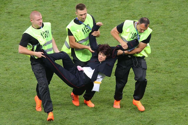 Security carry a protester from the pitch at the World Cup final