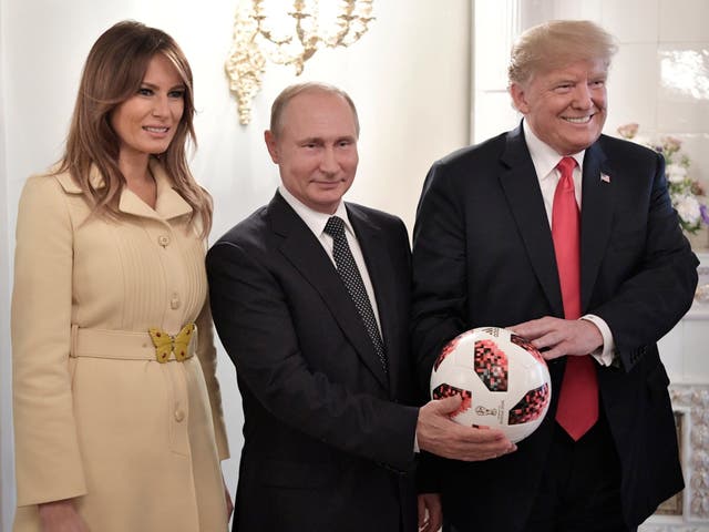 Melania Trump, Vladimir Putin and Donald Trump pose with a football after their meeting at the Presidential Palace in Helsinki