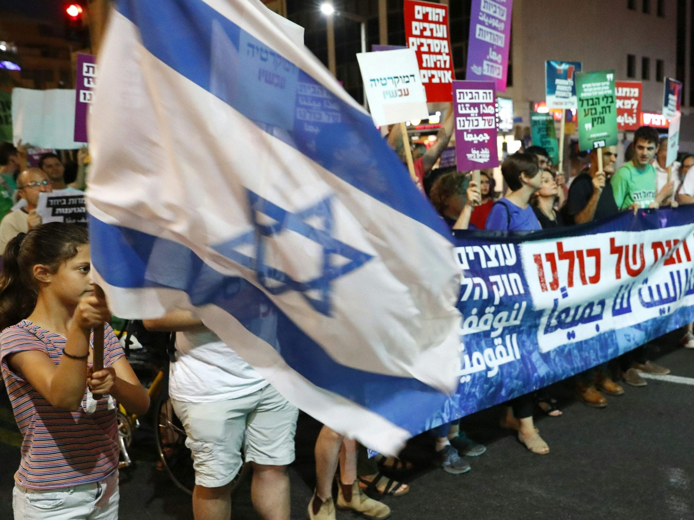 Demonstrators attend a rally in Tel Aviv to protest against the Jewish nation state bill