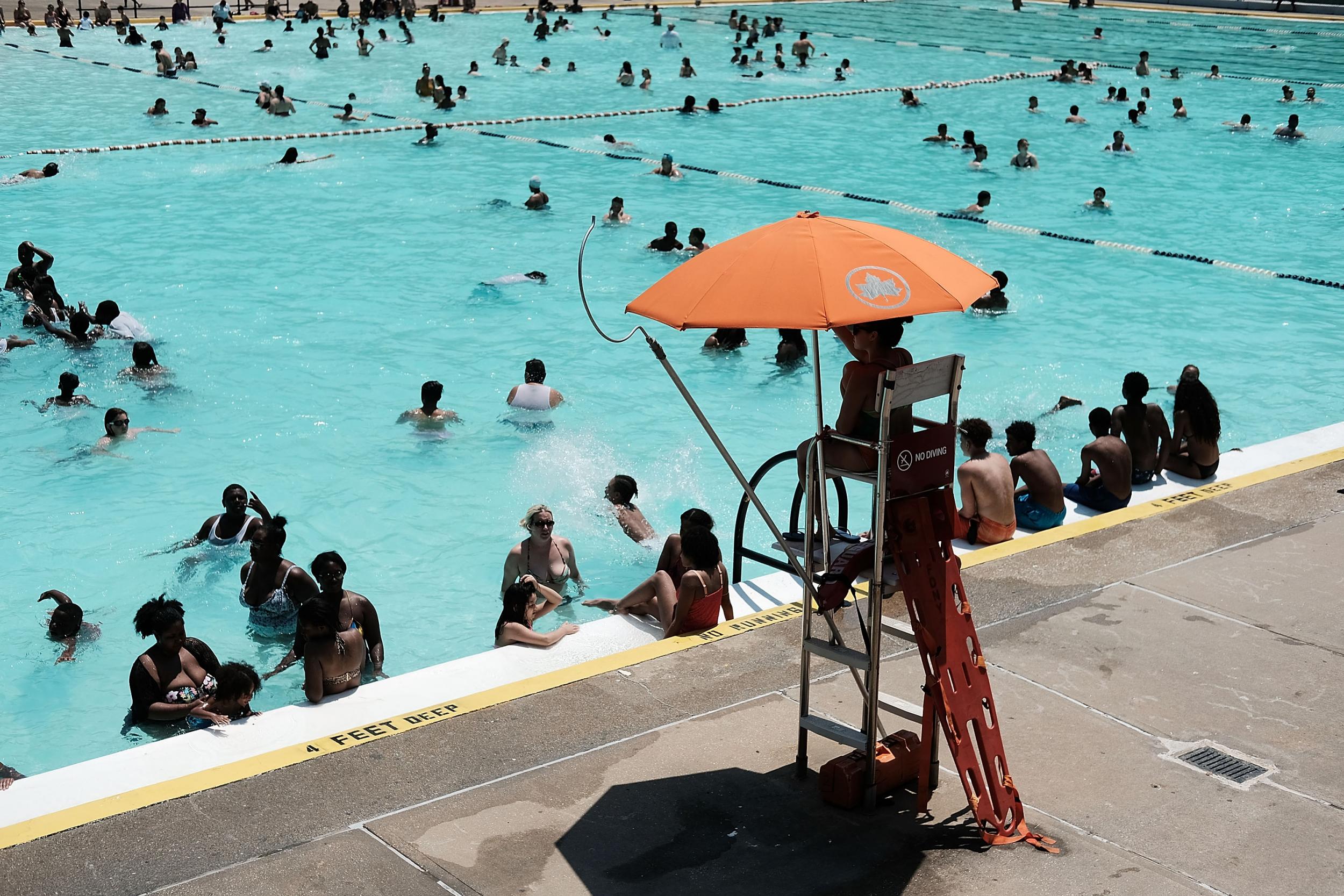 People enjoy a hot afternoon at a different swimming pool in New York City