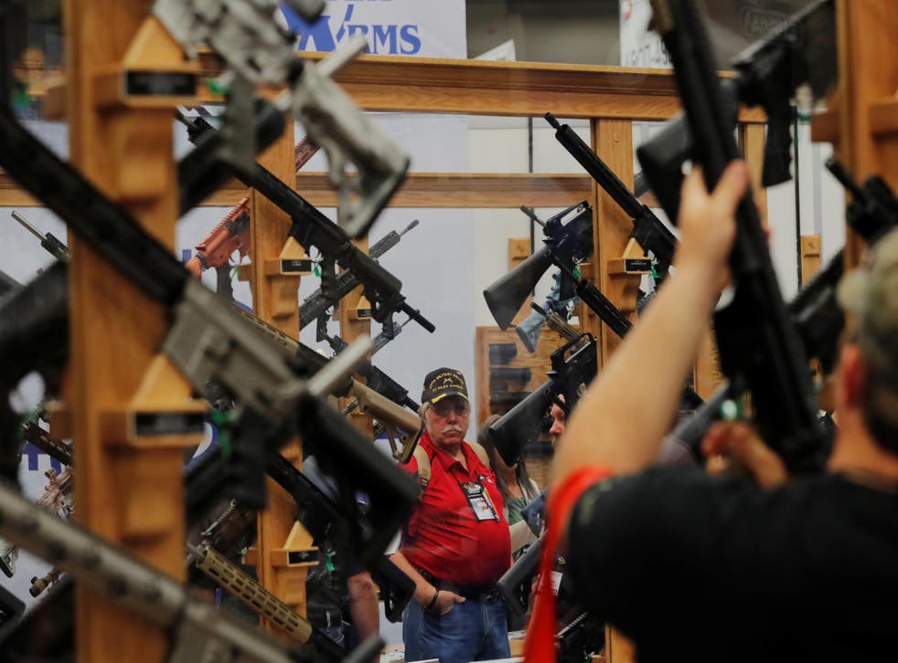 Gun enthusiasts look at rifles during the annual National Rifle Association (NRA) convention in Dallas, Texas, U.S., May 5, 2018. 